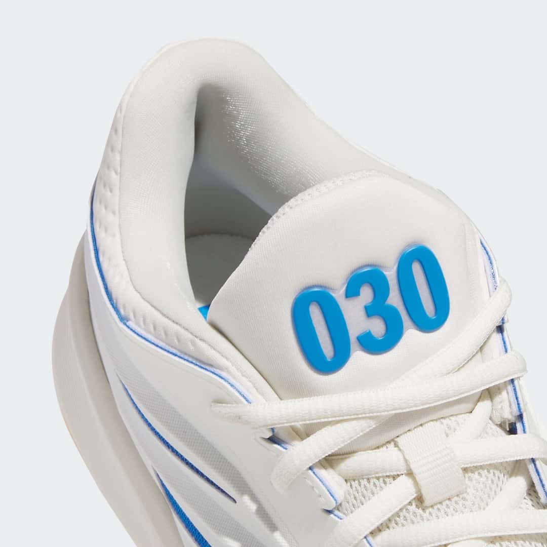 Detalle de la lengüeta de la adidas Crazy Energy Wagner Brothers con el número 030 en azul en relieve, cordones color crudo y vivos azules en el cuello