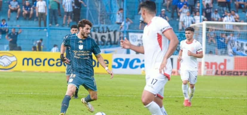 Un jugador de Atlético Tucumán, con camiseta celeste, conduce la pelota ante la marca de futbolistas de Barracas Central, de blanco, en el estadio José Fierro