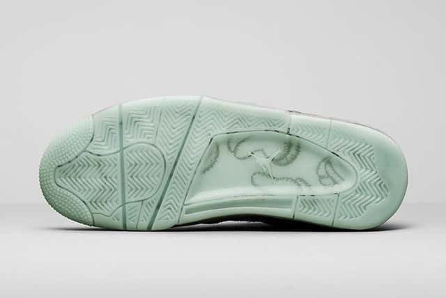 Foto de archivo: suela del KAWS x Air Jordan 4 Cool Grey de 2017, translúcida en verde agua, con las manos del personaje de KAWS y el Jumpman visibles debajo del caucho