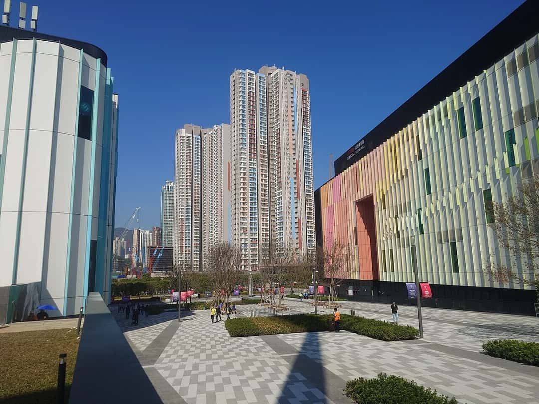 Plaza del Kai Tak Sports Park, el complejo de Hong Kong donde está el Kai Tak Stadium, con edificios de fachadas de colores y torres de departamentos al fondo. Foto: Ceeseven, CC BY-SA 4.0, vía Wikimedia Commons