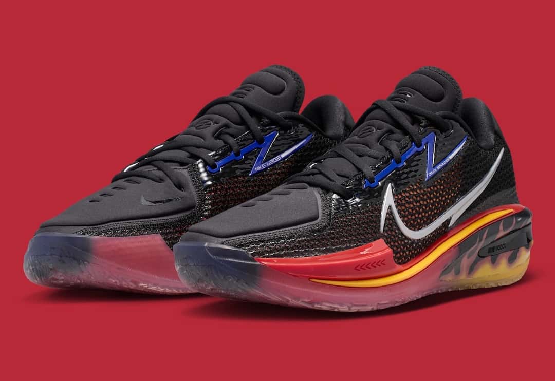 Par del Nike GT Cut 1 Hot Rod en vista de tres cuartos con malla negra, detalles azules en los cordones, Swoosh plateado y la mediasuela roja con llamas