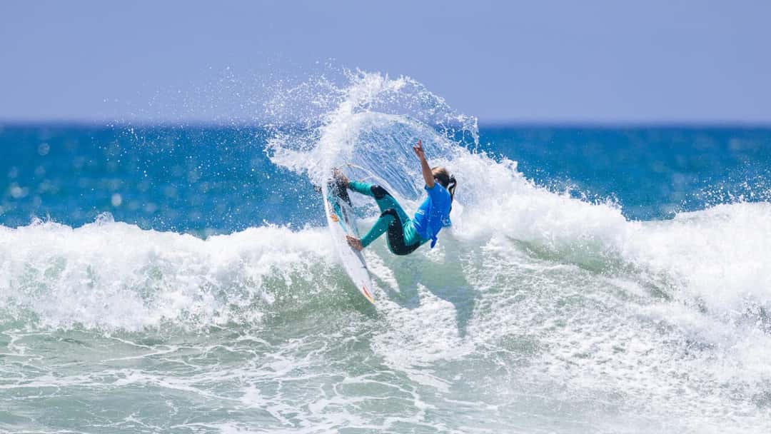 Sierra Kerr hace un giro cerrado con mucha espuma sobre una ola, con la lycra celeste de la WSL