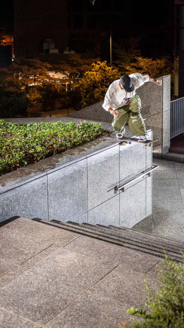 Ryuhei Kitazume hace un switch backside tailslide sobre un borde de granito junto a una escalera, de noche