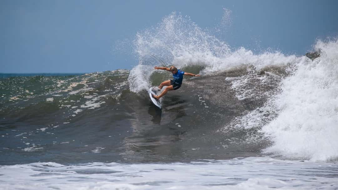 Yolanda Hopkins, con la lycra azul de la WSL, gira con los brazos abiertos en la cresta de una ola y levanta una cortina de agua, en una fecha anterior (foto de archivo)