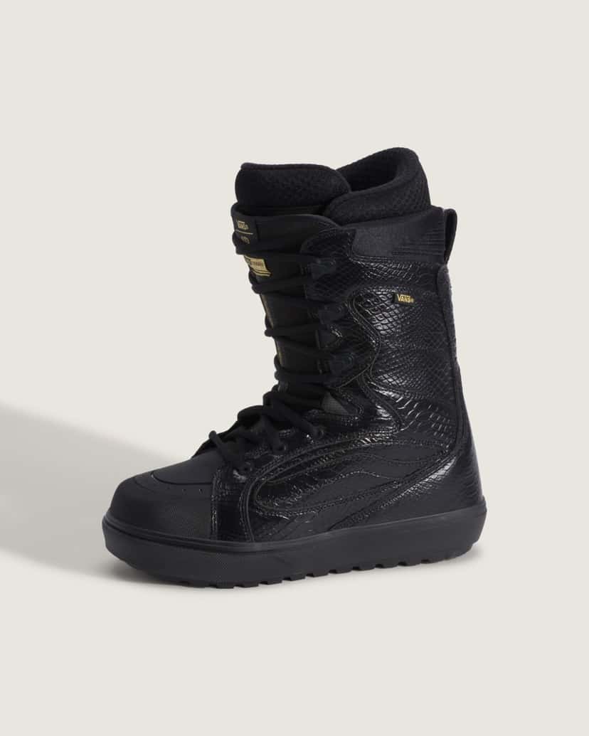 Bota de snowboard Vans Super Standard by Ryo Aizawa de perfil sobre fondo claro, negra con textura de serpiente, cordones negros, etiquetas doradas en la lengüeta y suela negra