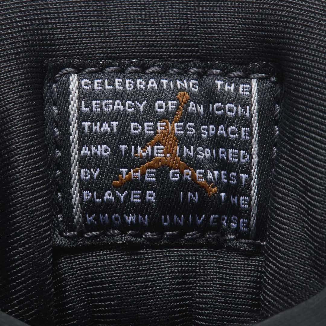 Etiqueta interna tejida del Air Jordan 11 WMNS Magic Ball, en negro con letras blancas y un Jumpman bordado en cobre, con la leyenda Celebrating the legacy of an icon that defies space and time