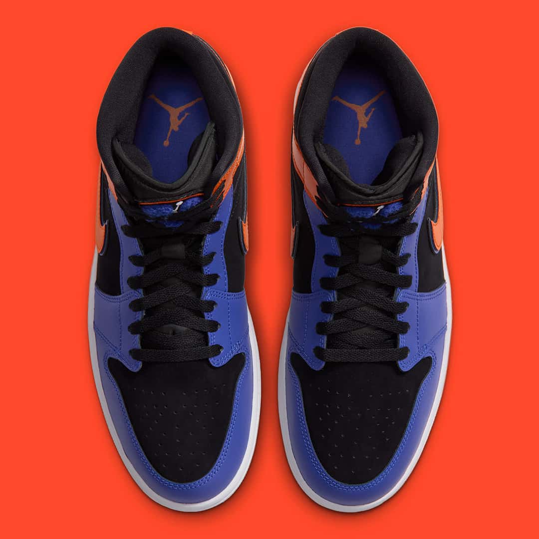 Par de Air Jordan 1 Mid Knicks visto desde arriba sobre fondo naranja, con el logo Jumpman naranja en la plantilla