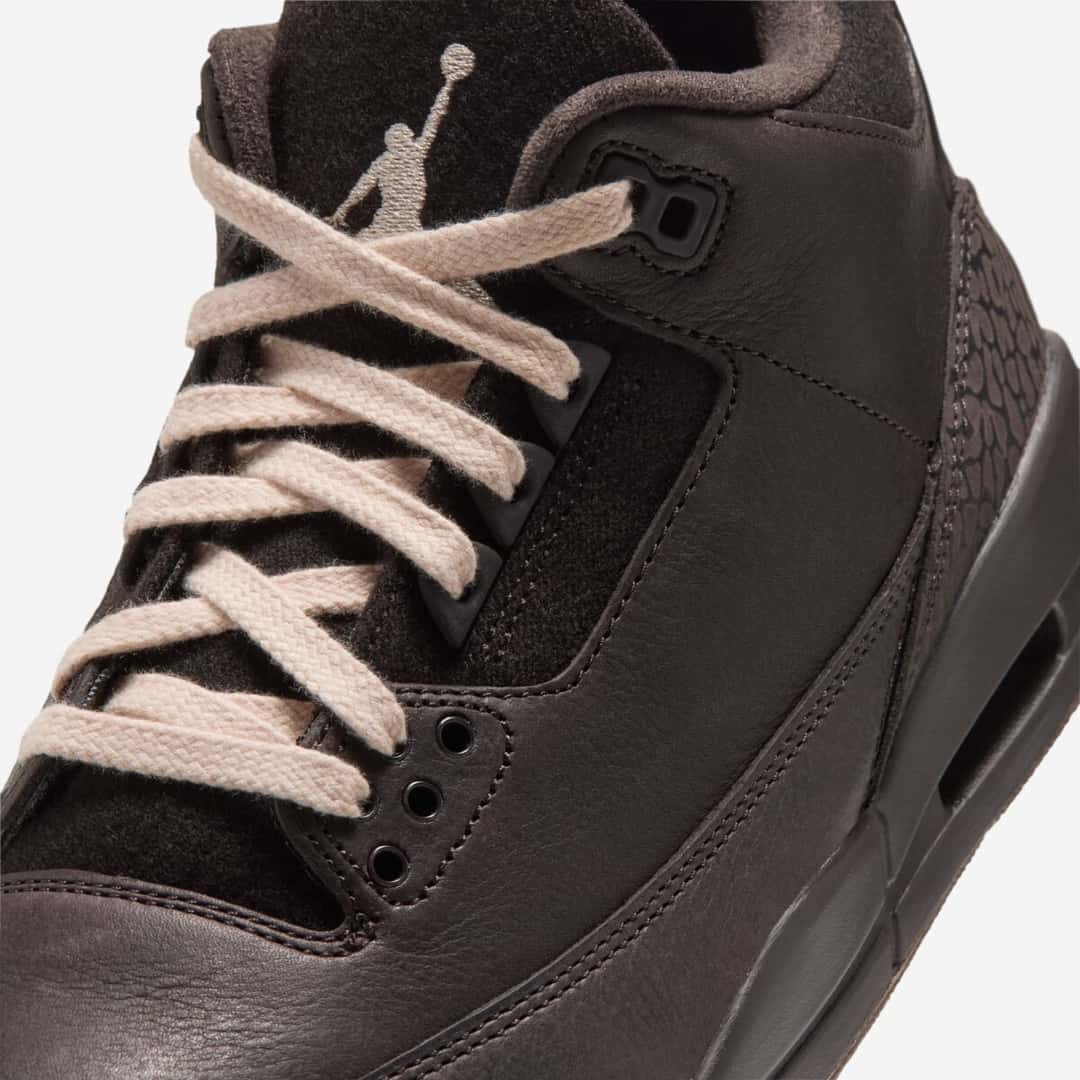 Primer plano del Air Jordan 3 Fireside con cordones crema cruzados, Jumpman beige bordado en la lengüeta marrón, ojales oscuros, cuero marrón con textura y el elephant print en el mismo tono cerca del talón