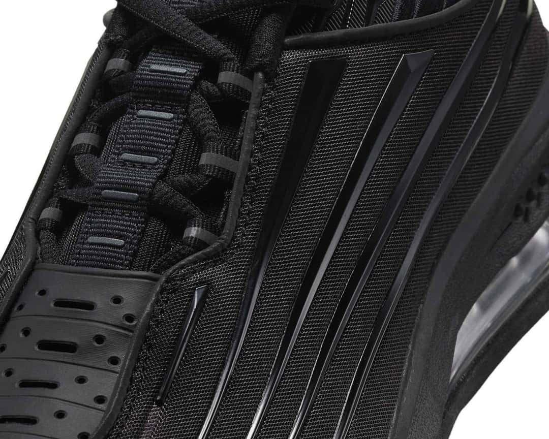 Primer plano del Nike Air Max Ecstasy Plus Triple Black con los cordones negros, la malla de la capellada y las franjas de TPU que bajan por el lateral