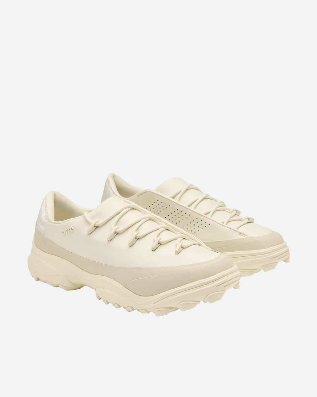 Par de la Arte Antwerp x adidas GSG9 Off White en vista de tres cuartos sobre fondo blanco, con el upper crudo, la palabra arte en relieve en un lateral, perforaciones en el lateral interno del otro pie, cordones redondos con pasadores y la suela de tacos marcados