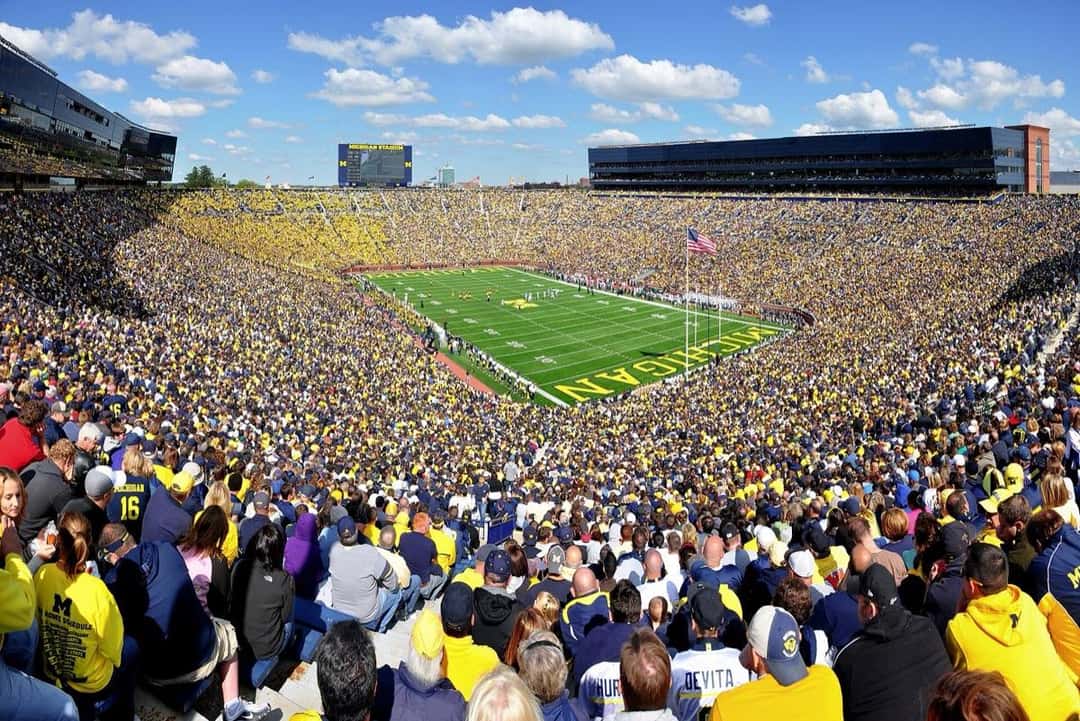 Estadio de la Universidad de Michigan lleno, con el campo de juego y las tribunas en amarillo y azul (foto: AndrewHorne, CC BY-SA 3.0, Wikimedia Commons)