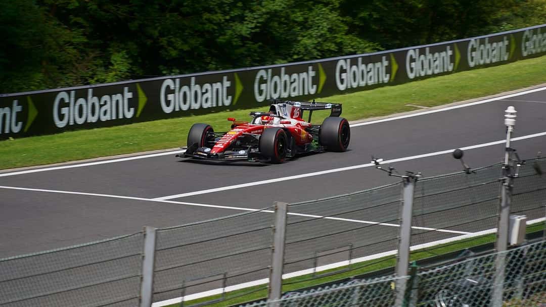 Foto de archivo: el Ferrari rojo de Charles Leclerc en una recta del circuito de Spa-Francorchamps, junto a un cartel publicitario, en 2026