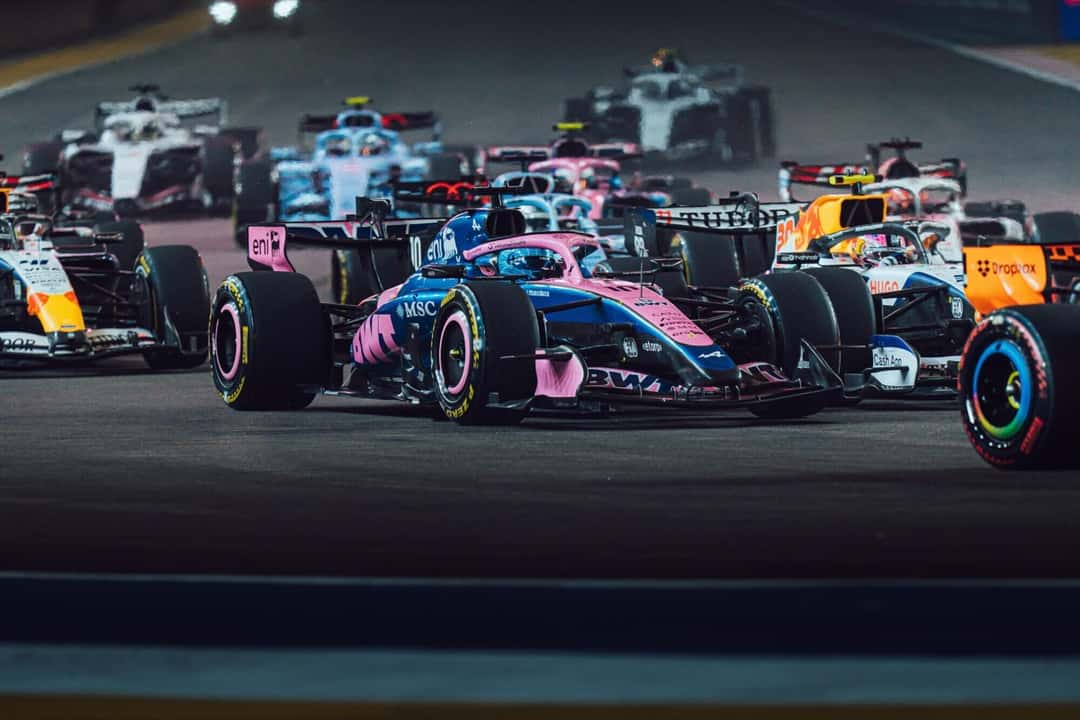 Pierre Gasly, con el Alpine número 10, en medio del pelotón en el arranque de la carrera de noche en Marina Bay