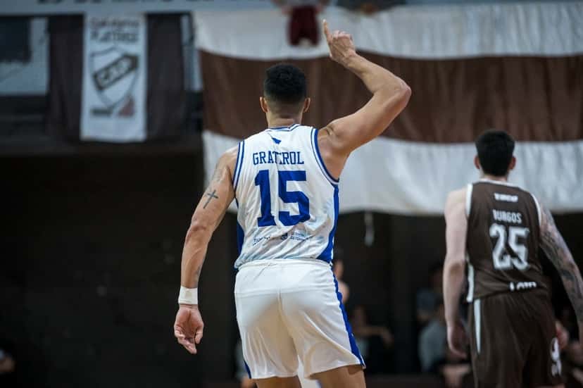 Windi Graterol, de La Unión de Formosa, de espaldas con la camiseta blanca 15, levanta el brazo derecho; a su lado, un jugador de Platense con la camiseta marrón 25