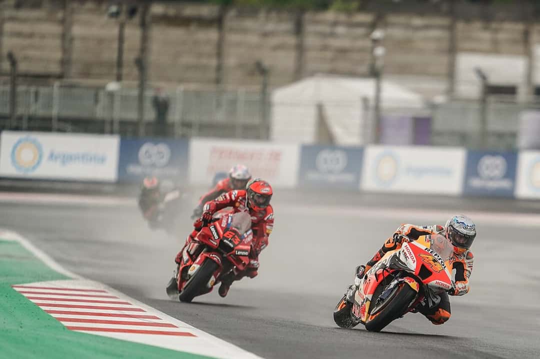 Foto de archivo: Pol Espargaró, con la Honda naranja y roja, encabeza un grupo de motos bajo la lluvia en Mandalika, seguido por la Ducati roja de Francesco Bagnaia