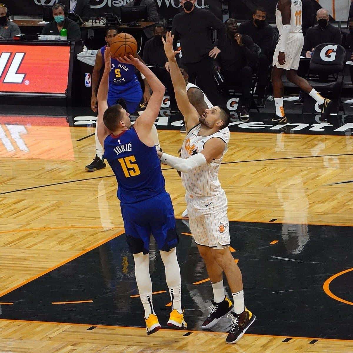 Foto de archivo: Nikola Jokic, con la camiseta azul número 15 de los Nuggets, lanza en suspensión por encima de un rival de Orlando