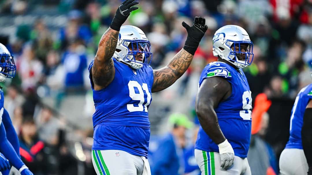 Dos defensores de los Seahawks, de azul, levantan los brazos para festejar una jugada ante los Chiefs en el Lumen Field