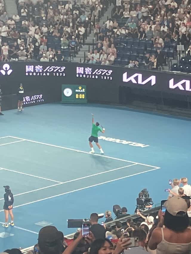 Foto de archivo: Novak Djokovic, con remera verde, saca en la cancha central del Abierto de Australia, con las tribunas llenas