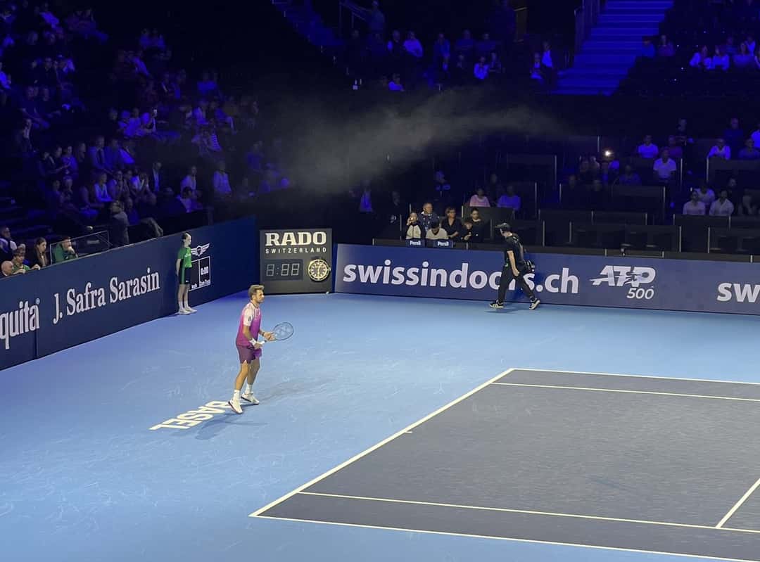 Foto de archivo: Stan Wawrinka, con remera violeta, se prepara en el fondo de la cancha azul del torneo de Basilea, con los carteles del torneo detrás