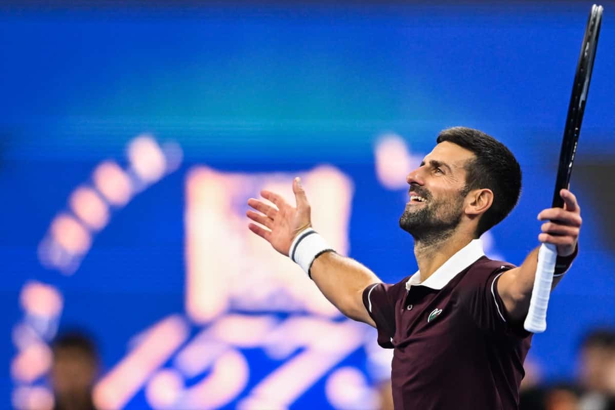 Novak Djokovic, con remera bordó, abre los brazos y sonríe en la cancha del China Open 2026, durante su partido de cuartos de final