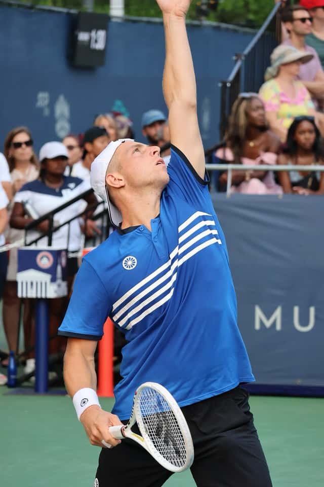 Foto de archivo: Tallon Griekspoor, de remera azul, saca con el brazo estirado hacia arriba en el torneo de Washington 2023