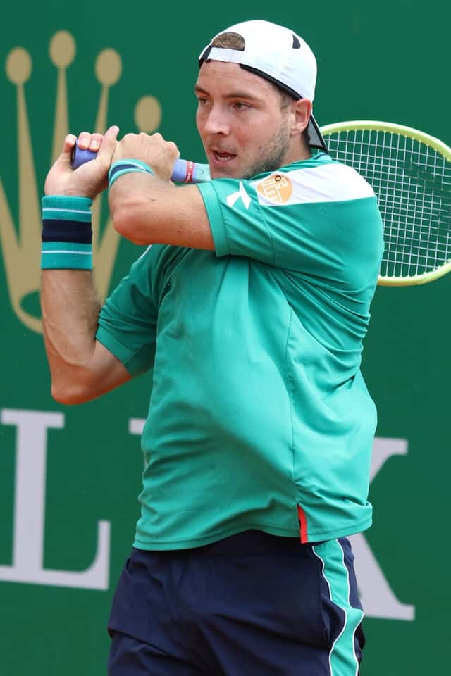 Foto de archivo: Jan-Lennard Struff, con remera verde y gorra blanca hacia atrás, prepara un revés de dos manos en un torneo de 2023
