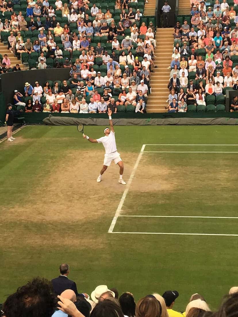 Foto de archivo: Juan Martín del Potro, de blanco, saca en una cancha de césped de Wimbledon ante una tribuna llena, en 2018