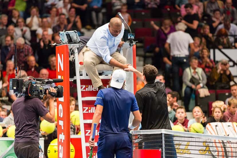 Foto de archivo: el juez de silla y dos jugadores se saludan junto a la red en el Erste Bank Open de Viena, con la tribuna llena detrás