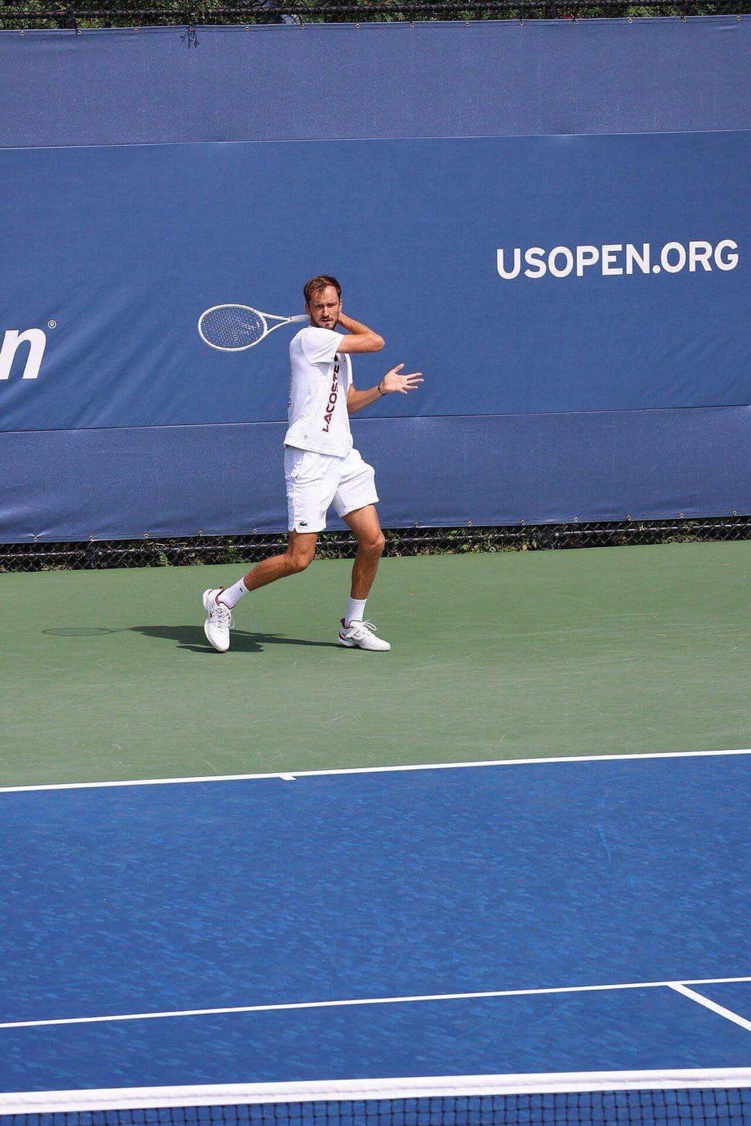 Foto de archivo: Daniil Medvedev, de blanco, prepara un drive frente al cartel del US Open 2023