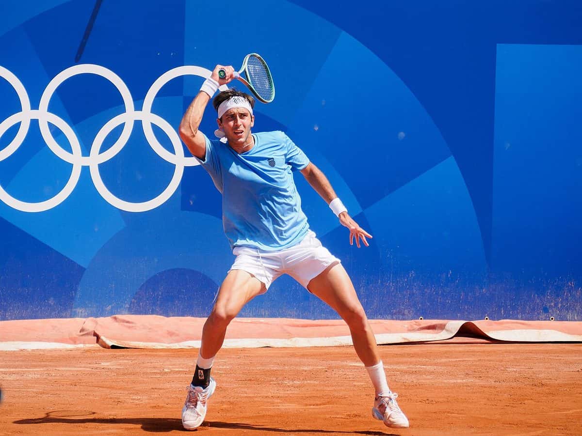 Foto de archivo: Tomás Etcheverry, con remera celeste y vincha blanca, le pega un drive en polvo de ladrillo en los Juegos Olímpicos de París 2024