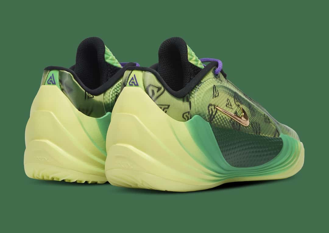 Talones de un par de Nike Giannis Freak 8 «Halloween» sobre fondo verde, con el contrafuerte esculpido en amarillo pálido, el logo GA violeta en la parte de arriba y la capellada verde translúcida con monogramas