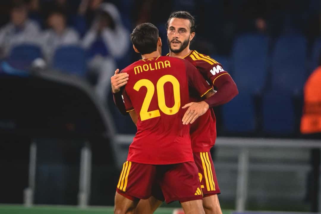 Nahuel Molina, de espaldas con la camiseta bordó de la Roma, el número 20 y su apellido, se abraza con un compañero para festejar en el estadio Olímpico (foto: AS Roma)