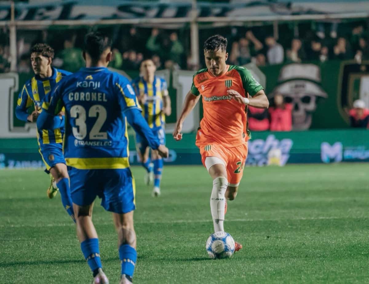 Un jugador de Banfield, con la camiseta naranja y verde, conduce la pelota ante Emanuel Coronel, de Rosario Central, en el estadio Florencio Sola durante el partido del lunes 5 de octubre. Foto difundida por Banfield