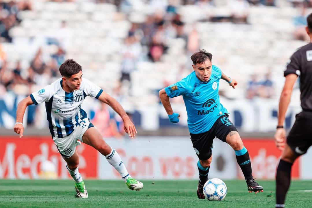 Un jugador de Belgrano conduce la pelota perseguido por un futbolista de Talleres en el Kempes (foto: prensa Club Atlético Belgrano)