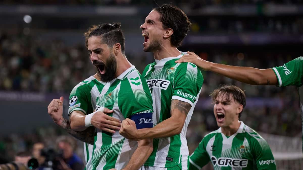 Isco, con la cinta de capitán, grita un gol abrazado por sus compañeros del Real Betis durante el partido de Champions League ante el Porto en La Cartuja (foto: Real Betis Balompié)