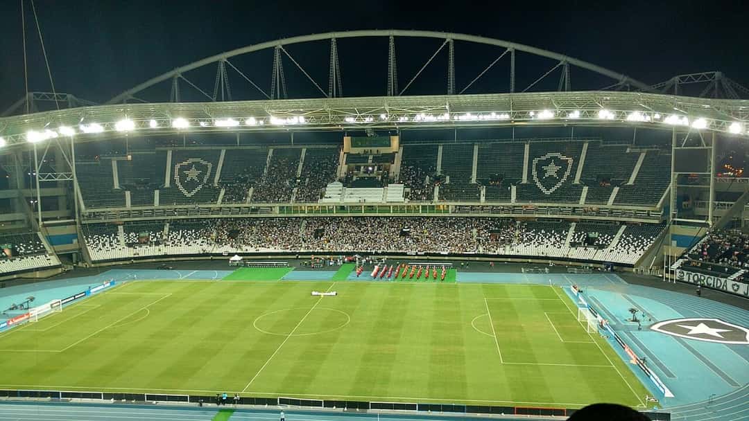 El campo de juego y las tribunas del estadio Nilton Santos iluminados de noche, antes de un partido de Copa Libertadores; foto de archivo de 2017 (foto: Phill ad, Wikimedia Commons, licencia CC BY-SA 4.0)