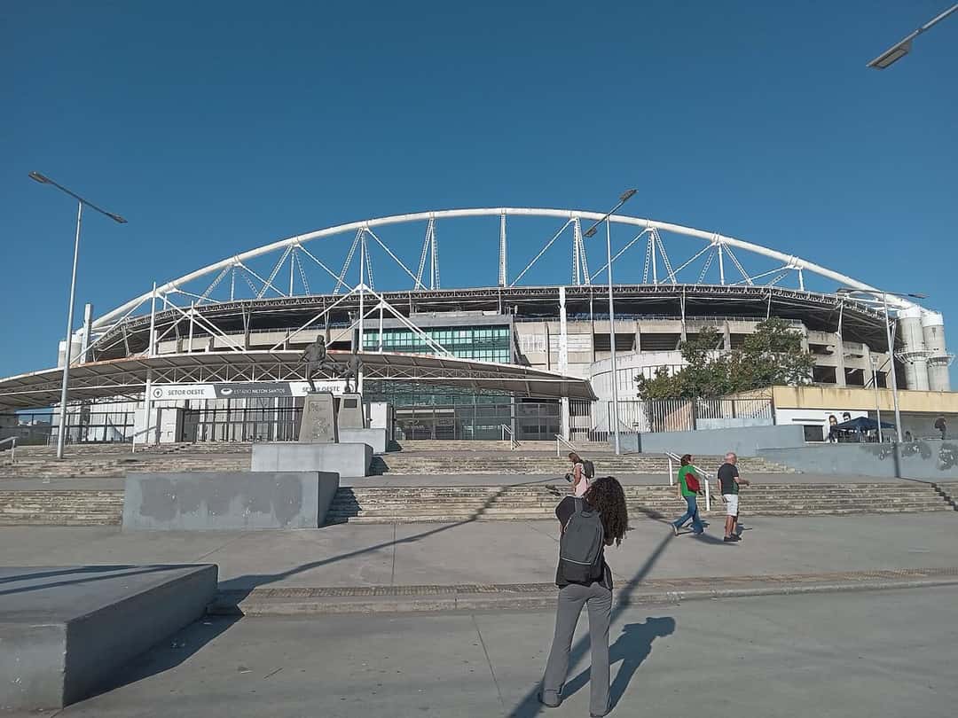 El acceso al estadio Nilton Santos, en Engenho de Dentro, con su arco metálico sobre la tribuna y el cielo despejado; foto de archivo de julio de 2025 (foto: Thayga Gil, Wikimedia Commons, licencia CC BY-SA 4.0)