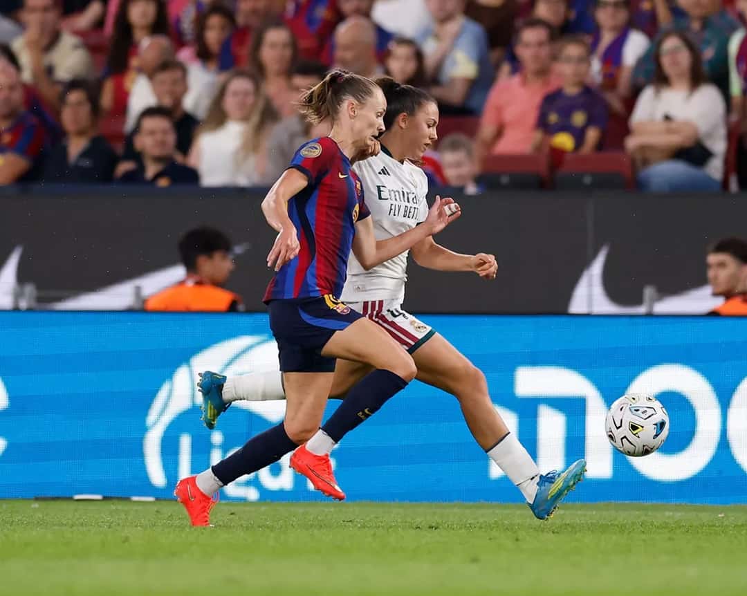 Una futbolista del Barcelona y una del Real Madrid corren detrás de la pelota en el Spotify Camp Nou. Foto: Real Madrid C. F.