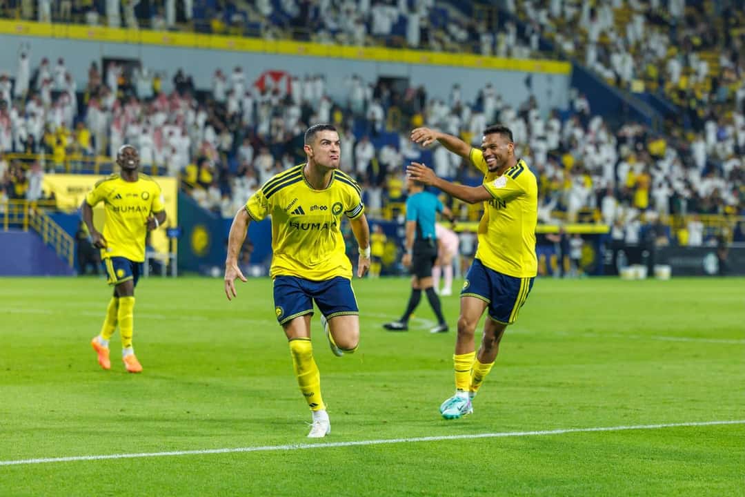 Cristiano Ronaldo, con la camiseta amarilla del Al Nassr, corre a festejar uno de sus tres goles mientras un compañero llega a abrazarlo, con la tribuna llena detrás, en el partido con el Al Kholood del jueves 29 de octubre de 2026 (foto: prensa Saudi Pro League)