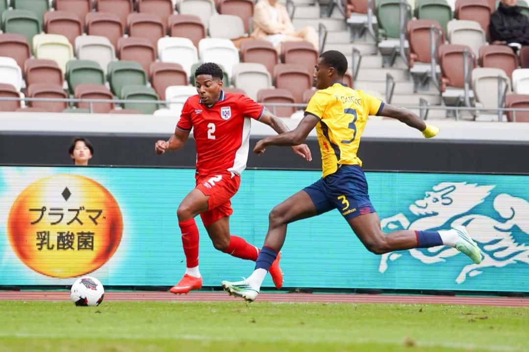 Fricio Caicedo, de Ecuador, con la camiseta 3, corre detrás de César Blackman, de Panamá, junto a la línea lateral del Estadio Nacional de Tokio (foto: Federación Panameña de Fútbol)