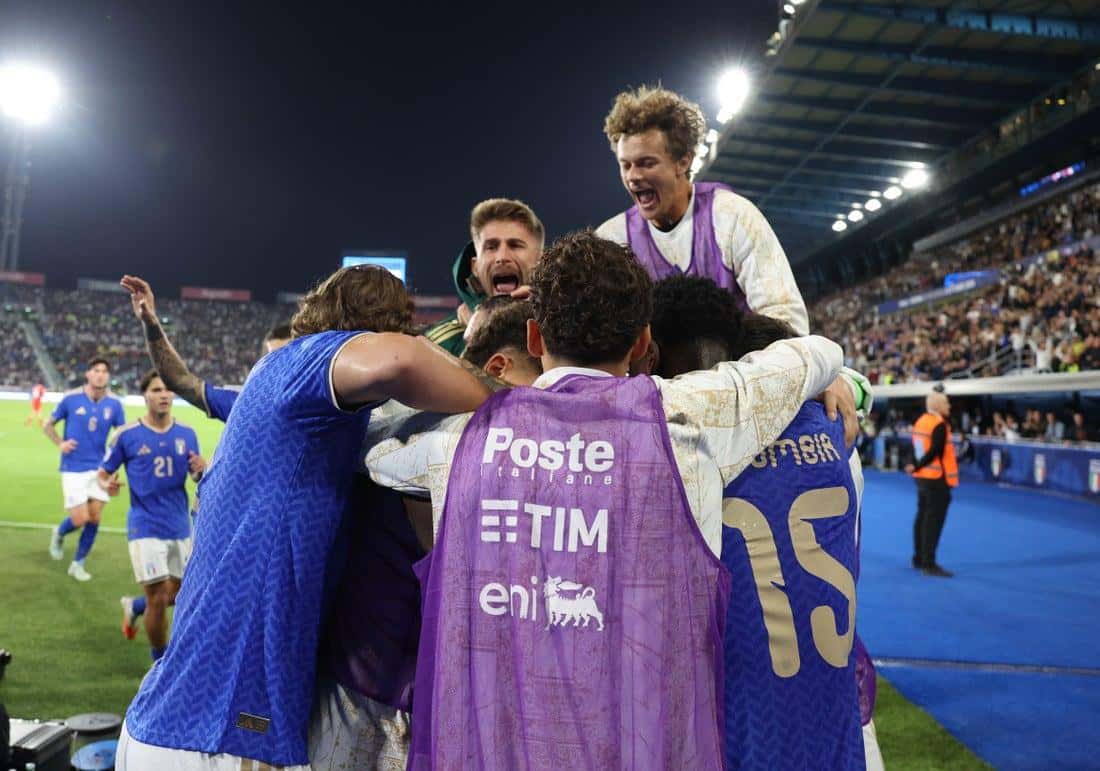 Jugadores titulares y suplentes de Italia, algunos con pecheras violetas, se abrazan para festejar un gol ante Turquía en el estadio Renato Dall'Ara de Bologna (foto: prensa oficial de la FIGC)