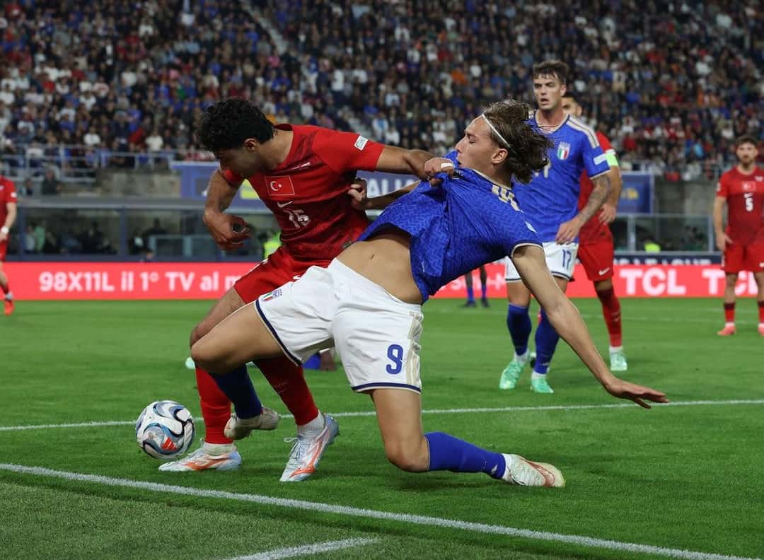 Francesco Pio Esposito, con la camiseta 9 de Italia, pelea la pelota con un defensor de Turquía cerca de la línea lateral en el Dall'Ara (foto: prensa oficial de la FIGC)