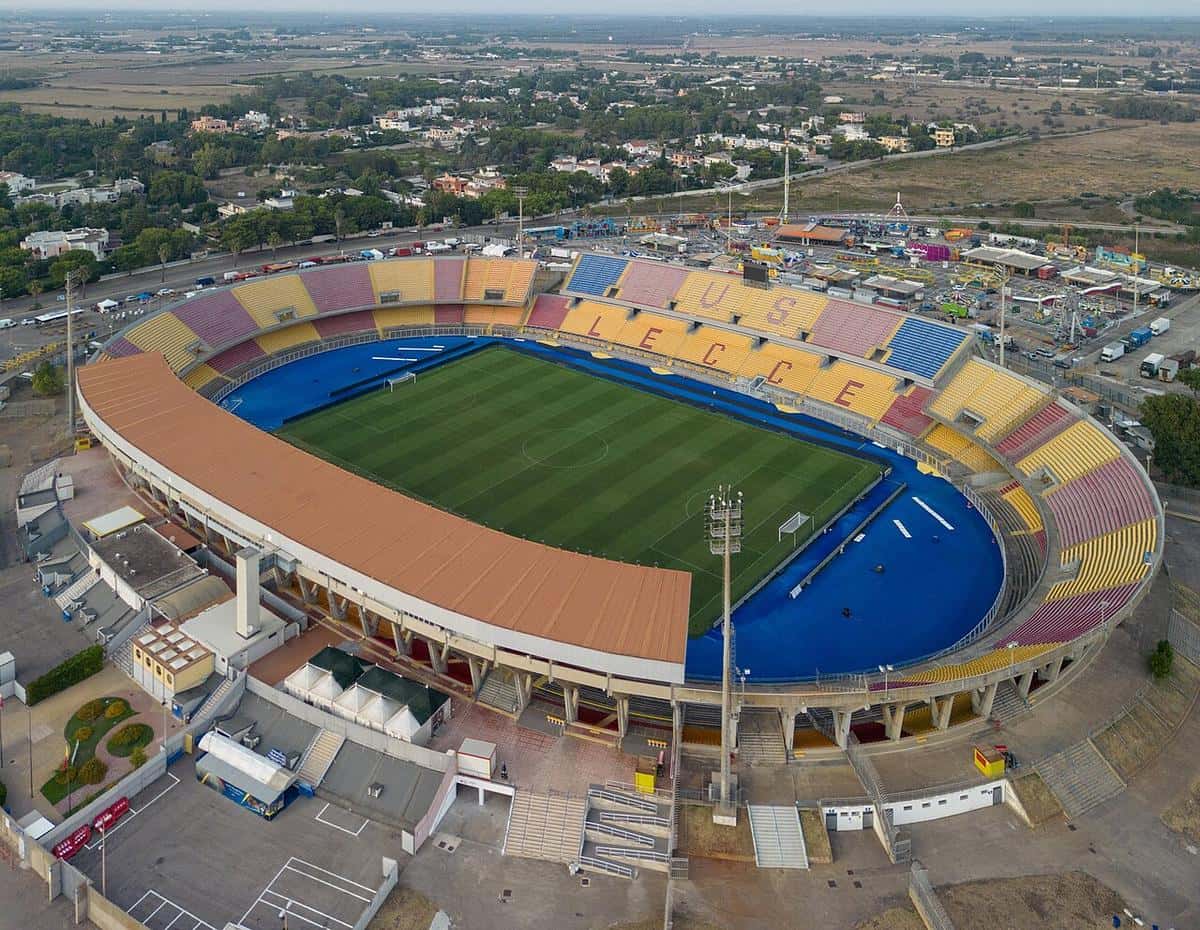 Vista aérea del estadio Via del Mare de Lecce, con las tribunas amarillas y rojas, la pista azul y la cancha de césped; foto de archivo de agosto de 2023 (foto: ParisTaras, Wikimedia Commons, licencia CC BY-SA 4.0)