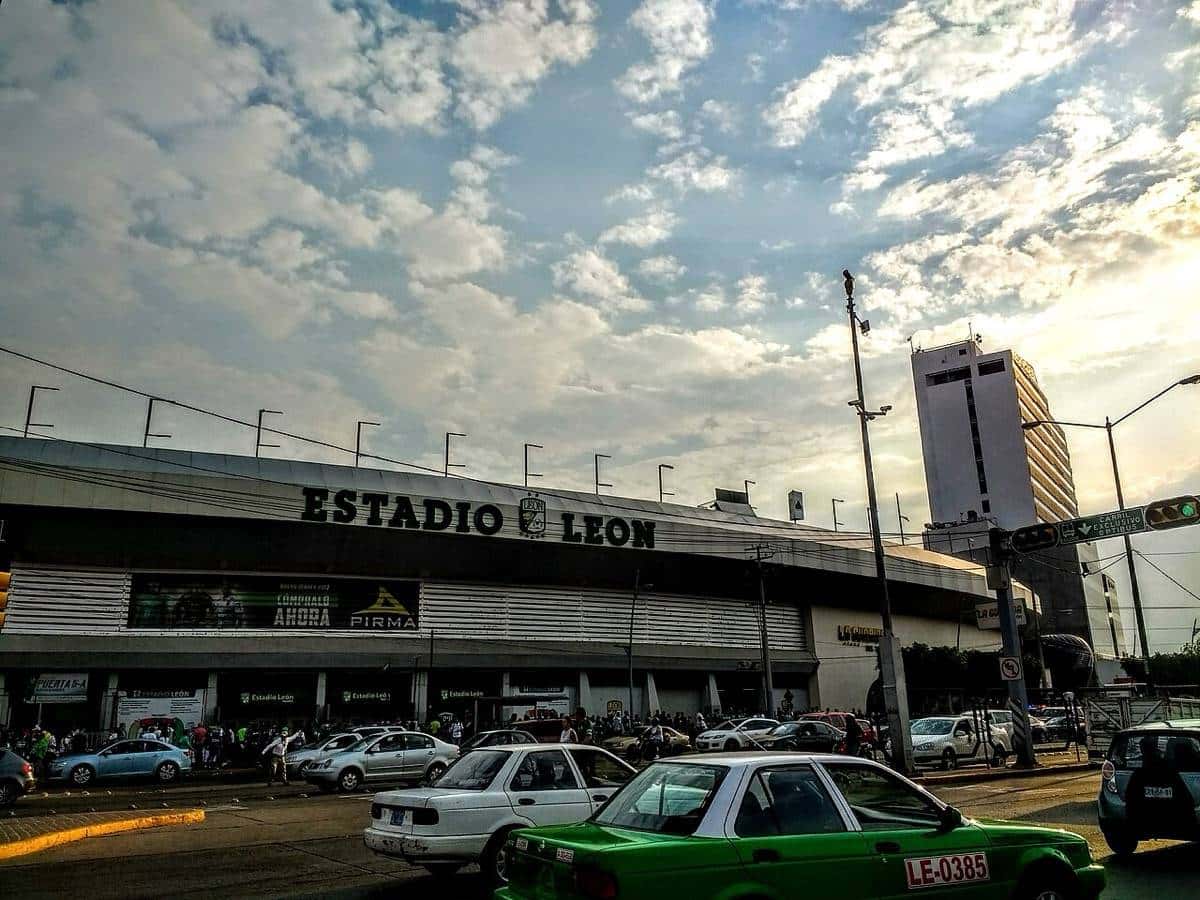 La fachada del estadio León, con el nombre en letras grandes sobre la entrada y autos estacionados en la calle; foto de archivo de 2017 (foto: PabloBWV, Wikimedia Commons, licencia CC BY-SA 4.0)