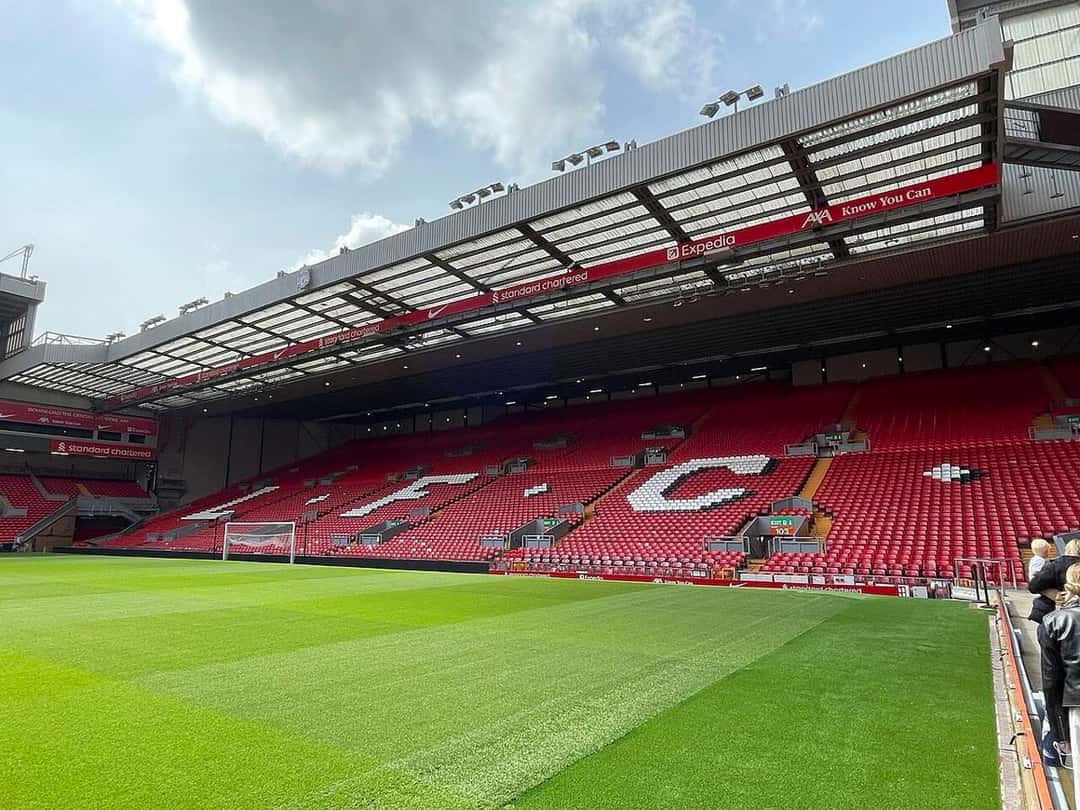 La tribuna del Kop de Anfield vista desde el borde de la cancha, con las butacas rojas y las letras blancas que forman la sigla del club; foto de archivo de mayo de 2024 (foto: FYI2023, Wikimedia Commons, dominio público CC0)