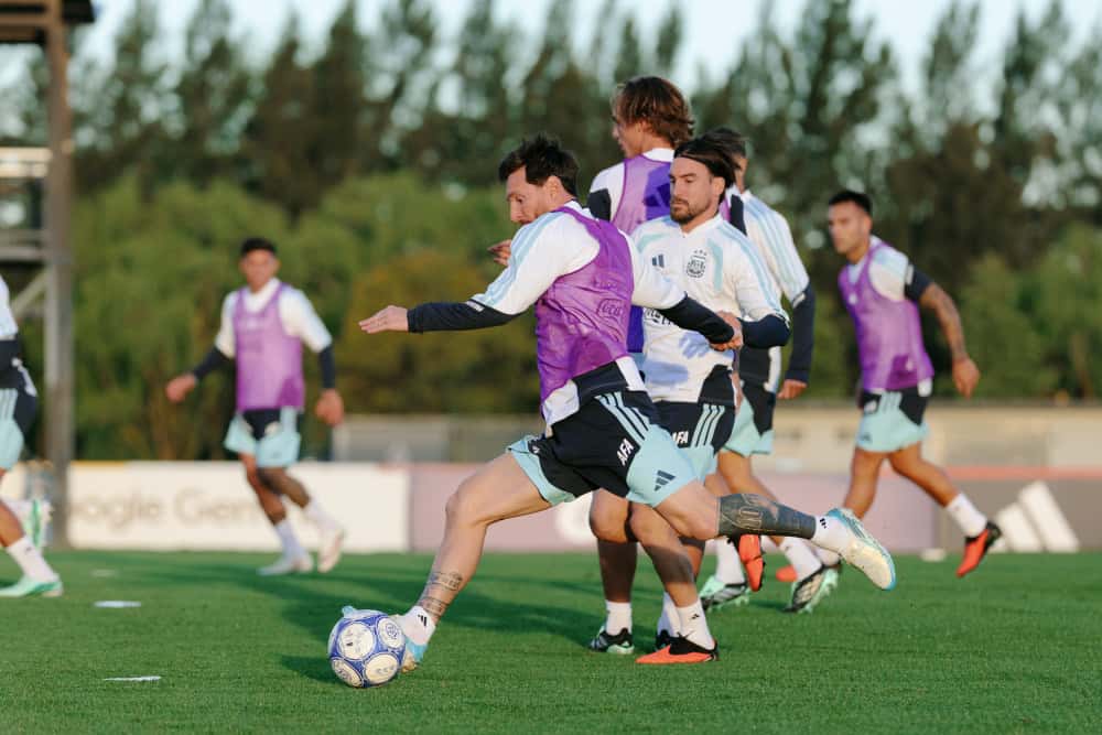 Lionel Messi, con pechera violeta, patea una pelota en el último entrenamiento de la Selección Argentina en el predio de Ezeiza, el lunes 5 de octubre, rodeado de compañeros (foto oficial de la AFA)