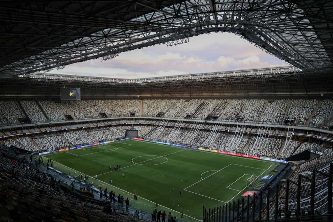 La Arena MRV de Belo Horizonte vista desde lo alto de una de sus tribunas, con el campo de juego iluminado y el techo metálico que cubre las gradas; foto de archivo (foto: Daniela Veiga / prensa oficial de Atlético Mineiro)