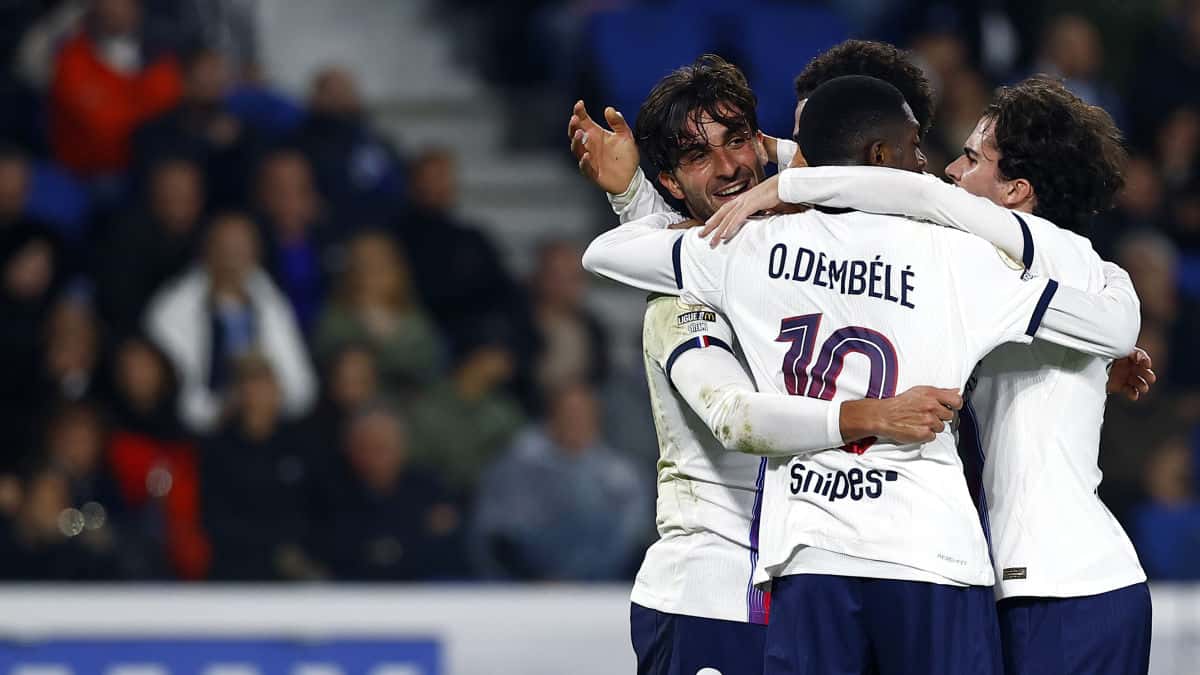 Ousmane Dembélé, de espaldas con el número 10 en la camiseta blanca del PSG, festeja abrazado por sus compañeros en el estadio de La Meinau (foto: prensa Paris Saint-Germain)