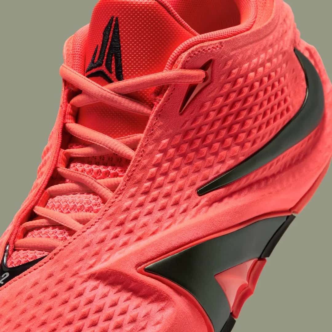 Detalle de la Nike Ja 4 Code Red, con la textura de la capellada roja, el Swoosh oscuro y el logo de Ja Morant en la lengüeta