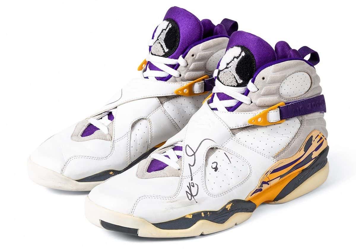 Par de Air Jordan 8 exclusivas de Kobe Bryant, blancas con violeta y amarillo, con la firma de Kobe en marcador negro sobre el lateral